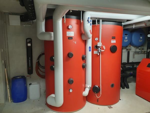 Zwei rote Speicher mit Rohrleitungen und Ausdehnungsgefäss